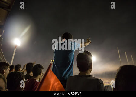 Un ragazzo fa un segno di pace dalle gabbie in Tishreen Stadium, durante la finale di Coppa siriano, ottobre 2017. Il calcio siriano cup finale è stata giocata tra Al-Wahda Al-Karamah e squadre di calcio. Nonostante il conflitto in corso in un paese lacerato dalla guerra di Siria, il calcio siriano cup finale è stata ospitata nella città capitale di Damasco che è sotto il governo siriano di controllo con molti locali per gli appassionati di calcio hanno assistito alla partita. Foto Stock