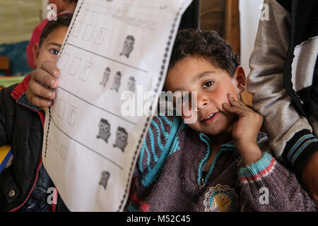 Bambini siriano mostrare i loro lavori scolastici in un campo profughi nella valle di Bekaa. Più di un milione di Aramei fuggirono in Libano dopo la guerra siriana ha cominciato in 2011. Foto Stock