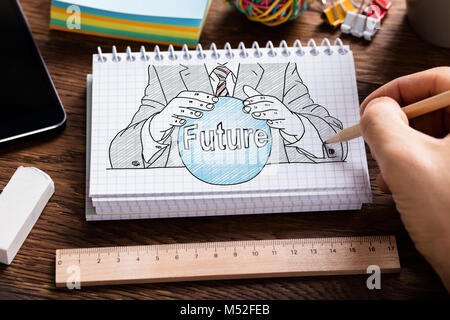 Commercianti di mano azienda disegno a matita Fortune Teller concetto di notebook a spirale con cancelleria Foto Stock