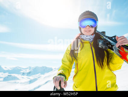 Foto della ragazza di sport che indossa il casco, una maschera con gli sci sulla sua spalla Foto Stock