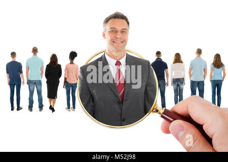 Close-up della mano che tiene la lente di ingrandimento ricerca candidato per l'assunzione Foto Stock