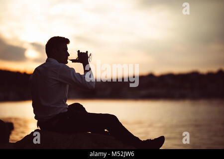 I giovani hanno sottolineato il business man bere solo vino.gradazione uomo infelice con la sua vita,addicted ad alcool.L' abuso di alcol.solo con un drink in mano. Foto Stock