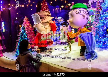 Bambina sguardi con stupore di Charlie Brown Christmas window display in flagship Macy's Department Store di New York City, NY, STATI UNITI D'AMERICA. Foto Stock