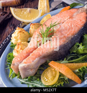 Salmone con burro fritto purea di patate e insalata mista Foto Stock