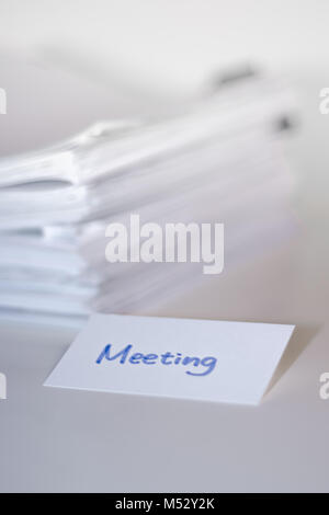 Riunione; pila di documenti sulla scrivania in bianco e lo sfondo. Foto Stock