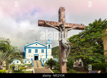 Ilhabela, Sao Pablo, Brasile - Febbraio 17th, 2018: un Crocifisso e la chiesa di Nostra Signora di aiuto (Nossa Senhora da Ajuda) al prof. Alfredo Oliani Foto Stock