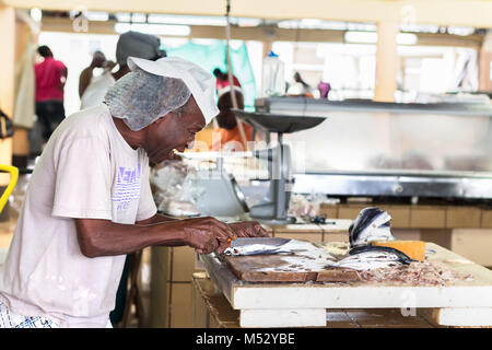 Bridgetown, Barbados - Gennaio 31th, 2018: un lavoratore di sesso maschile a Bridgetown Mercato del pesce è la preparazione di pesci volanti per la vendita. Foto Stock