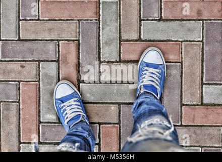 Gambe in blu sneakers Foto Stock