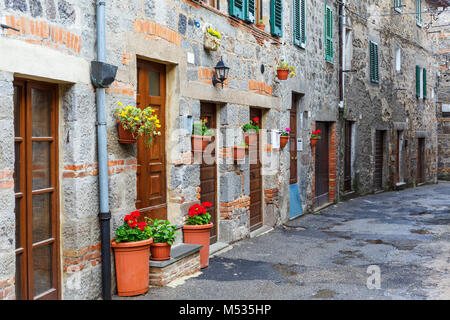 Street con fiori in vaso sulla parete Foto Stock