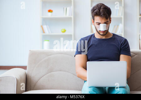 Giovane uomo recuperando la guarigione a casa dopo un intervento di chirurgia plastica del naso Foto Stock