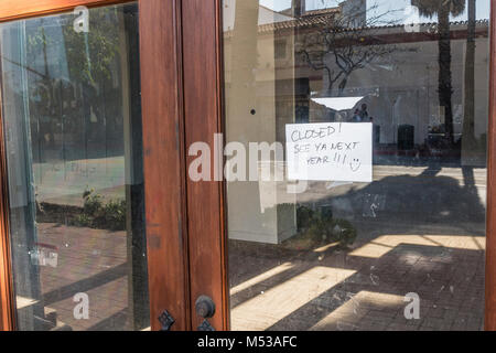 Un libro bianco il segno inviato su un negozio di vetro porta di ingresso con la notifica: 'See ya il prossimo anno!!!" con una faccina sorridente. Il negozio era una specialità st Foto Stock