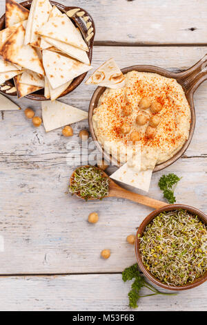 Hummus, ceci, dip con pane pita e germogli di broccoli Foto Stock