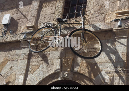 Vecchia bicicletta arrugginita appeso su una parete di Kavala, Macedonia, Grecia Foto Stock