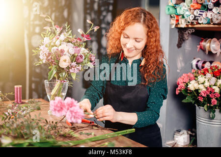 Giovane donna selezionando i fiori al mercato Foto Stock