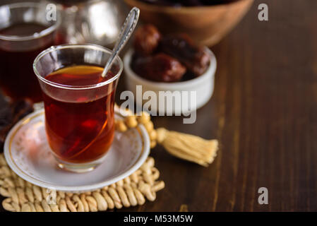 Datteri secchi Frutta con tè per iftar. I grani di preghiera sullo sfondo Foto Stock