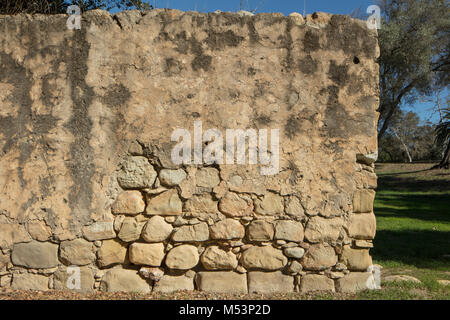 Dettaglio shot a livello degli occhi di una usura della parete in pietra arenaria con caratteristiche di erosione di esporre le pietre al di sotto. Foto Stock