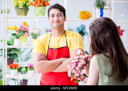 Un fioraio che vendono fiori in un negozio di fiori Foto Stock