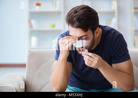 Giovane uomo recuperando la guarigione a casa dopo un intervento di chirurgia plastica del naso Foto Stock