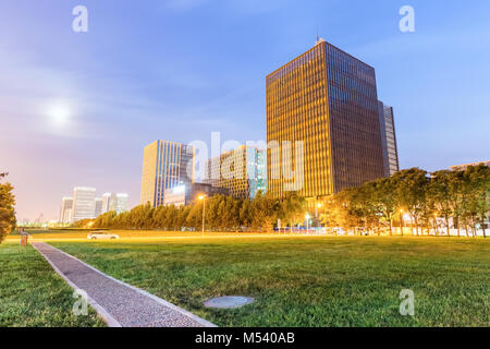 Sentiero del parco e prato con edifici moderni di notte Foto Stock