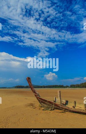 Relitto vecchia barca da pesca sepolto nella sabbia con cielo blu sul giorno nuvoloso sfondo Foto Stock