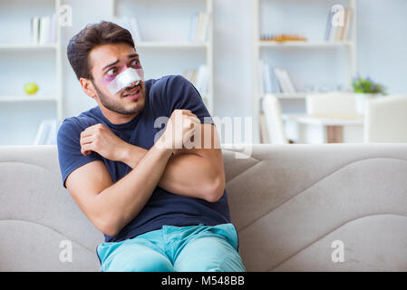 Giovane uomo recuperando la guarigione a casa dopo un intervento di chirurgia plastica del naso Foto Stock