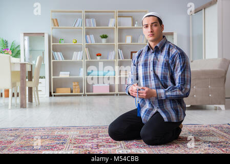 Giovani Musulmani uomo pregando in casa Foto Stock