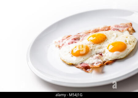 Prosciutto e uova. Uova e pancetta. Uovo salato con pepe sulla piastra bianca. Prima colazione inglese. Foto Stock