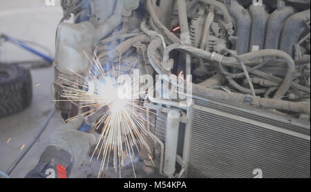 Concetto industriale: lavoratore che fa la saldatura in auto auto service Foto Stock