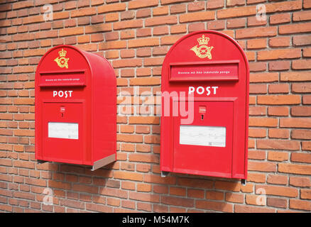 Rosso di caselle di posta su un muro di mattoni Foto Stock