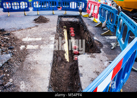 Installazione di nuovi tubi in strada di città, lavori di manutenzione, dig, la riparazione, la nuova tubazione dell'acqua. Foto Stock