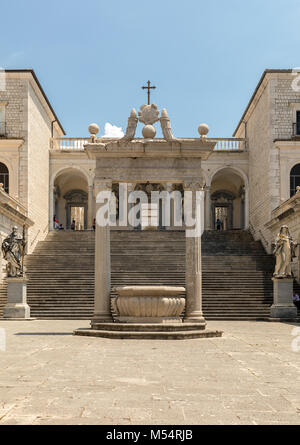 Monte Cassino, Italia - 17 Giugno 2017: cisterna e le statue di San Benedetto e di santa Scolastica nel chiostro del Bramante, abbazia benedettina di Monte Foto Stock