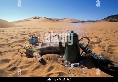 In Algeria. Nei pressi di Djanet. Deserto del Sahara. Le dune di sabbia. Camping bollitore e accessori. Campfire. Foto Stock