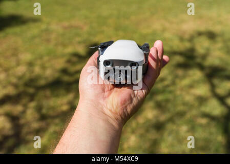 Un DJI Mavic aria drone ripiegato in un mans mano per mostrare le dimensioni del drone Foto Stock