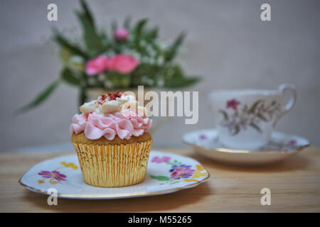 Vintage il tè del pomeriggio con cupcake su una piastra e fiori freschi Foto Stock