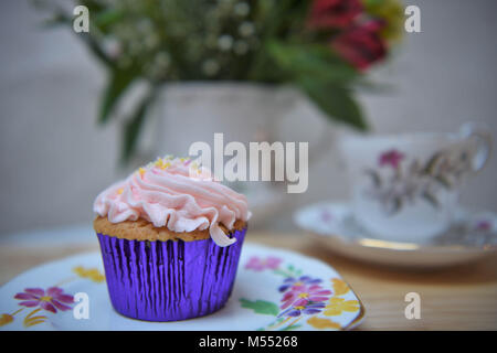 Vintage il tè del pomeriggio con cupcake su una piastra e fiori freschi Foto Stock