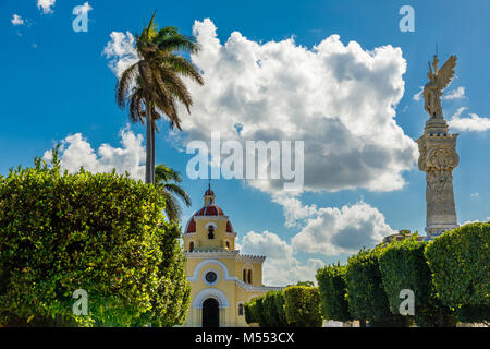 Cristobal Colon cimitero cattolico la cappella e la colonna con angelo in primo piano, Vedado, Havana, Cuba Foto Stock