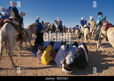 In Algeria. Vicino a Tamanrasset. Deserto del Sahara. Persone di etnia Tuareg durante il TAFSIT springfestival o. Gli uomini sui cammelli, le donne sedute sulla sabbia. Foto Stock