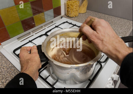 Fare marmellata fatta in casa con Saville arance di cottura in cui vi è un rischio elevato di zucchero mix di marmellata bollente sul fornello se dimentica di mantenere in agitazione Foto Stock