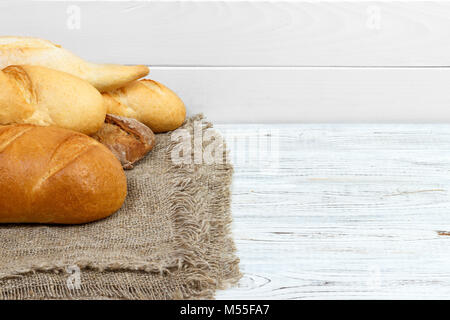 Pane baguette su bianco rustico in legno dipinto. Foto Stock