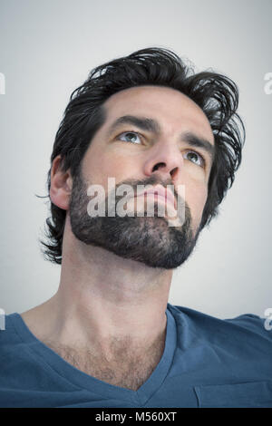 Uomo Barbuto guardando verso l'alto Foto Stock