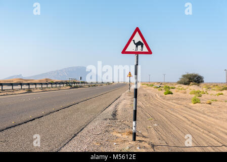 Segno posto accanto alla strada in una regione desertica driver per rendere consapevoli del possibile attraversamento di cammelli (dromedari) Foto Stock