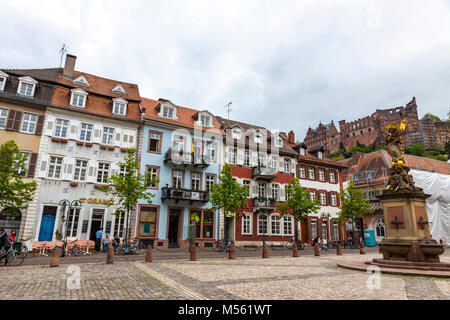 La gente che camminava sulla piazza Kornmarkt in Heidelberg Città vecchia, Germania. Madonna statua sul primo piano e del castello di Heidelberg sullo sfondo Foto Stock
