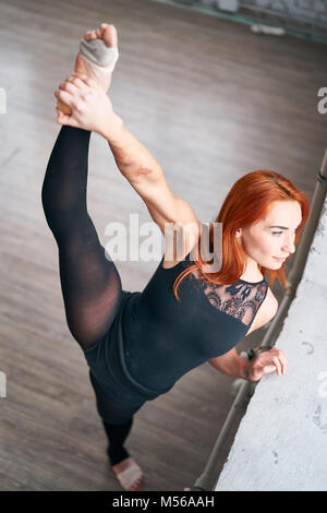 Ragazza ballerina facendo stretching vicino alla finestra Foto Stock