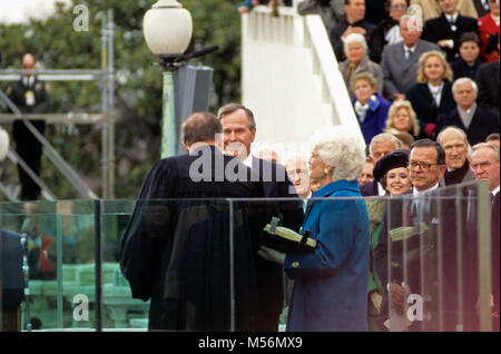 Il Presidente degli Stati Uniti George H.W. Bush è giurato-in come 41a Presidente degli Stati Uniti dal Chief Justice William Rehnquist presso il Campidoglio US on gennaio 20, 1989. La first lady Barbara Bush (indossando un mantello blu) guarda tenendo la famiglia la bibbia. Riconoscibili i membri del Congresso a destra ci includono il senatore Ted Stevens (Repubblicano dell'Alaska), US Senator Alan Simpson (Repubblicano del Wyoming), e l'altoparlante della Camera dei rappresentanti degli Stati Uniti Jim Wright (Democratico del Texas). Credito: Ron Sachs / CNP /MediaPunch Foto Stock