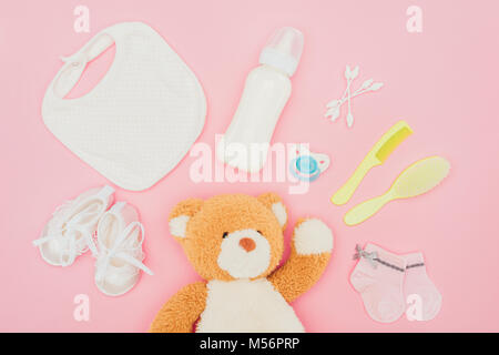 Vista dall'alto di Teddy bear e attrezzature bambino isolato in rosa Foto Stock