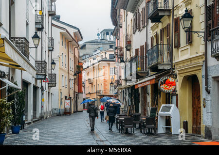 Aosta, Italia - Feb 17, 2018: strada commerciale durante una giornata di pioggia in italiano città alpina di Aosta nel nord Italia Foto Stock