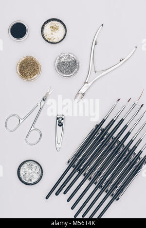Vista superiore del glitter e strumenti per manicure isolato su bianco Foto Stock