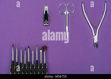 Vista superiore delle spazzole e manicure strumenti isolati su viola Foto Stock