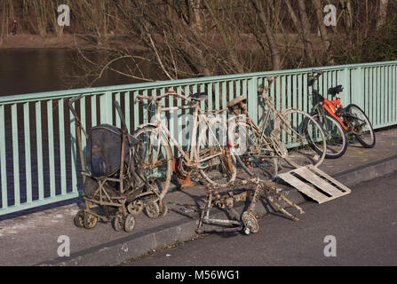 Biciclette e un passeggino disegnato fuori di un lago Foto Stock