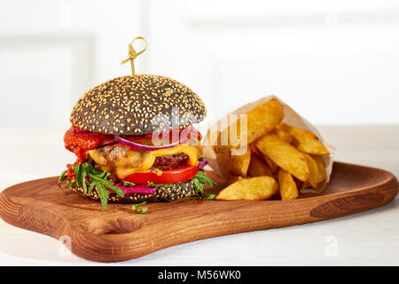 Nero cheeseburger e patatine Foto Stock